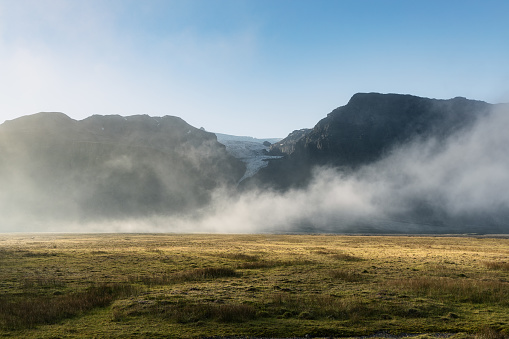 Mist over the glacier and mountains landscape in Icelandic countryside