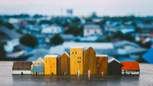 casa de madera, modelo de edificio de negocios sobre fondo de madera, un símbolo para la construcción, la ecología, el préstamo, la hipoteca, la propiedad o el hogar. - budget green business finance fotografías e imágenes de stock