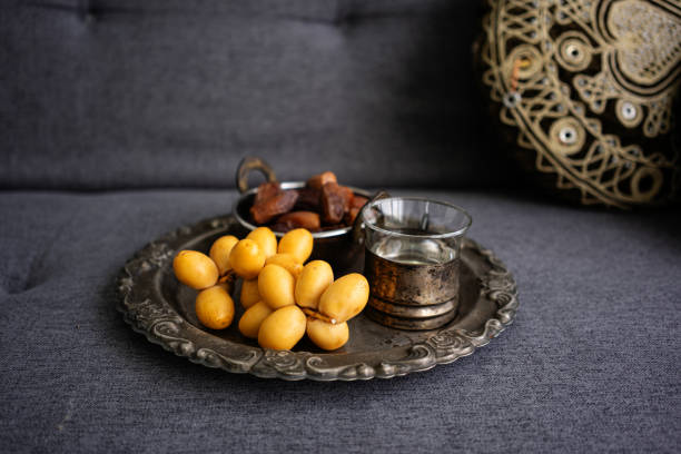 Dried date palm fruits on metal plate in living room