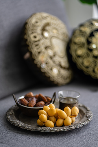 Dried date palm fruits on metal plate in living room