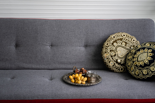 Dried date palm fruits on metal plate in living room