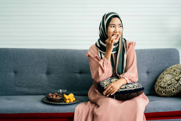 istock Young muslim woman eating date 1705160372