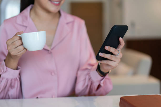 istock Female entrepreneur drinking coffee and using smartphone to reading financial data in home office 1705182122