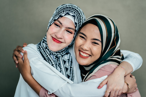 Two Muslim women greeting her friend and talking with smile
