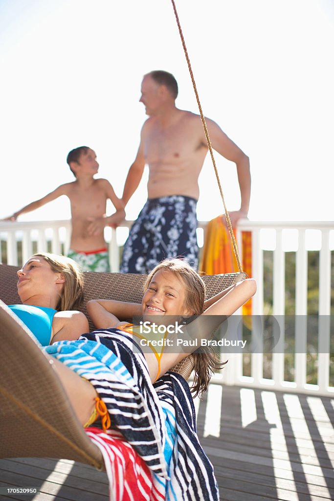 Famille se détendre sur une chaise longue sur la terrasse - Photo de 12-13 ans libre de droits