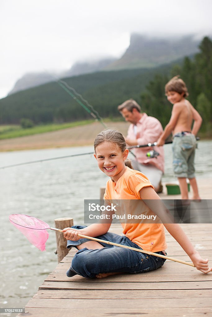 Ragazza con rete seduto sul molo a Lago - Foto stock royalty-free di 35-39 anni