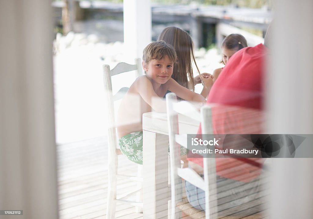 Famiglia seduta al tavolo - Foto stock royalty-free di 12-13 anni