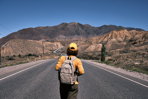 Female tourist is walking on mountain road