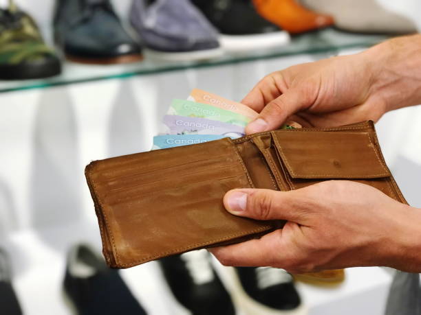 istock Man's hands holding wallet with Canadian dollars 1705240777