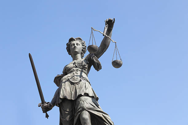 istock ancient lady Justice Justitia with  sword against  perfect  blue sky 170525860