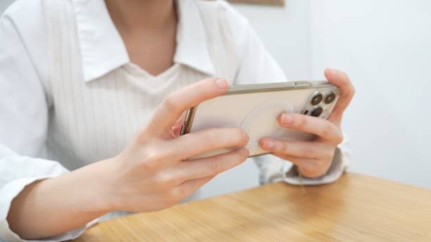 istock Two hands watching video online on playing mobile phone tap tapping touch touching screen using digital technology social communication smartphone online social media 1705263107