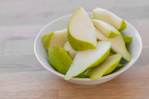 Sliced pear.cutting green pear into a plate .Fruit cut. Healthy fruit snack. fresh fruits in the diet