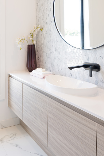 Cropped view of ceramic white basin and black tap in modern bathroom. Interior design idea. Home spa relaxation concept.