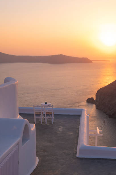 istock Two white chairs in a terrace for watching a romantic sunset landscape in the Mediterranean Sea in Santorini 1705408030