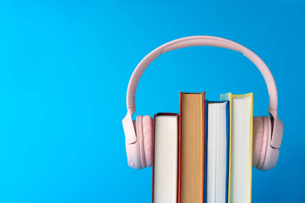 istock Pink headphones on stack of books against blue background 1705431715