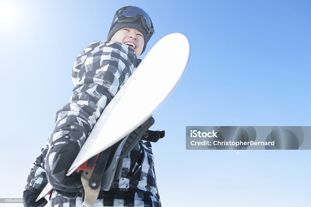Szczęśliwy mężczyzna snowboardzistka przeciw błękitne niebo - Zbiór zdjęć royalty-free (Przygoda)