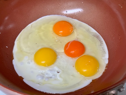 Photo of three colors of egg yolks in one frying pan