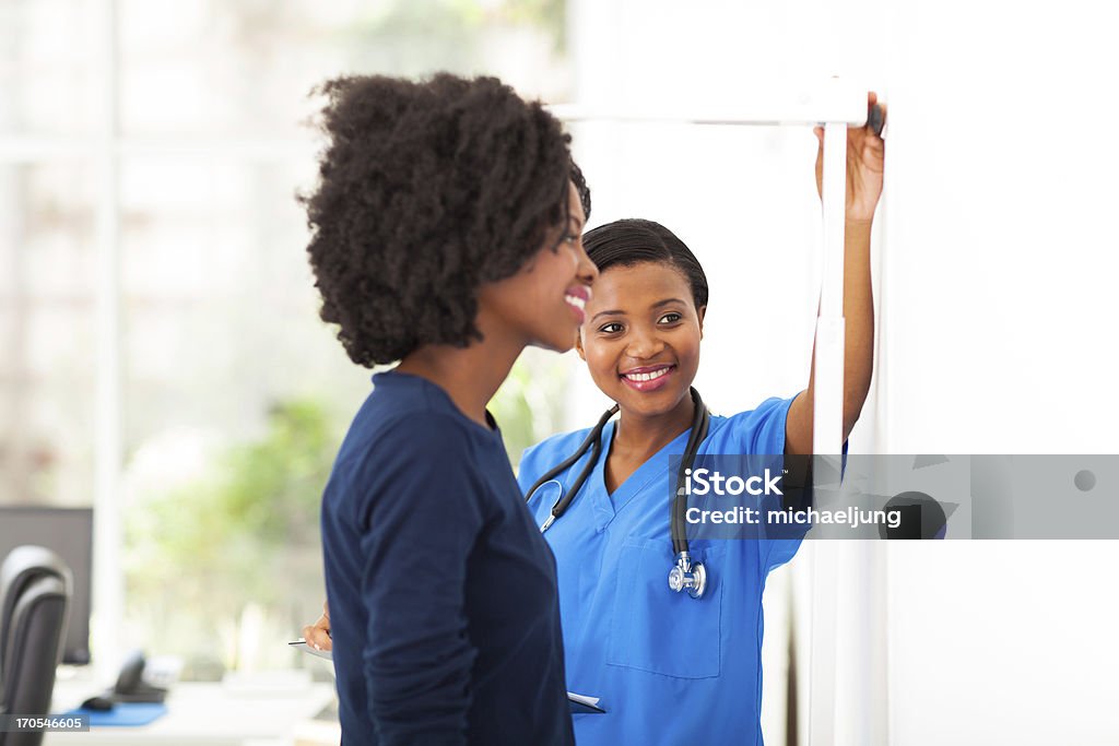 Infirmière africaine mesure patient de hauteur - Photo de Consultation médicale libre de droits