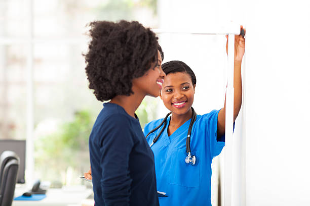 africana enfermeira medindo a altura do doente. - medical assistant imagens e fotografias de stock