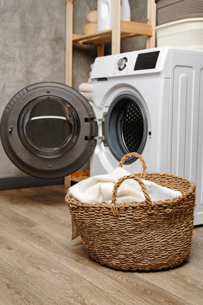istock Laundry room interior with washing machine near gray grunge wall 1705477052