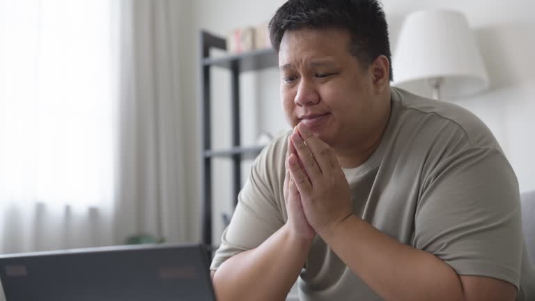 Frustrated man working at home using a laptop