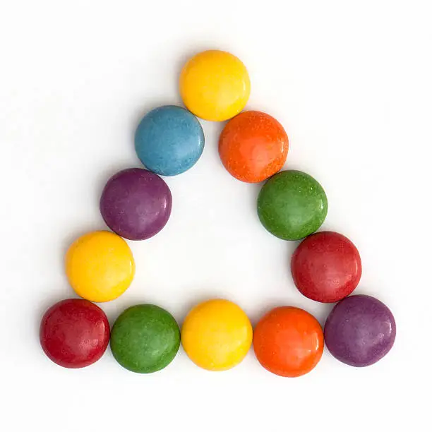 Colorful smarties stored in a triangle.