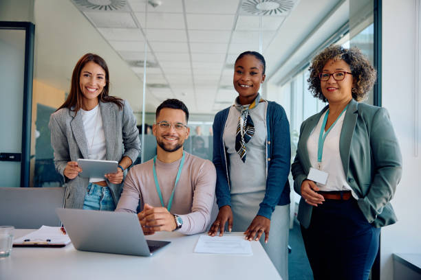 Happy multiracial business team working in the office and looking at camera.