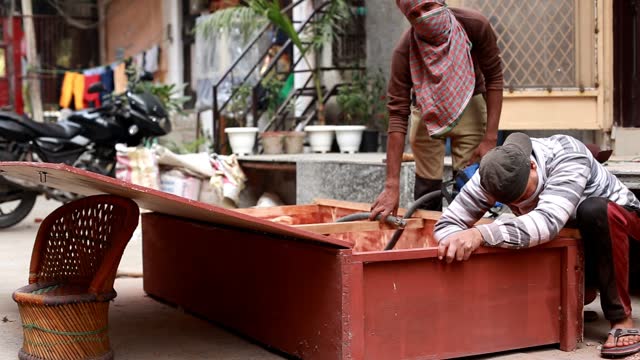 Two carpenter repairing bed at construction site