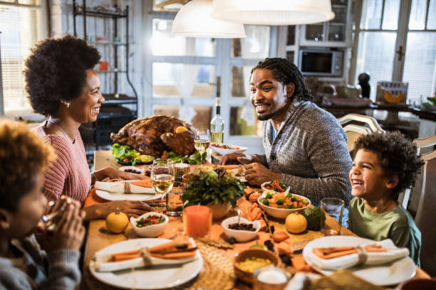 istock Happy black family communicating while having Thanksgiving meal in dining room. 1705496731