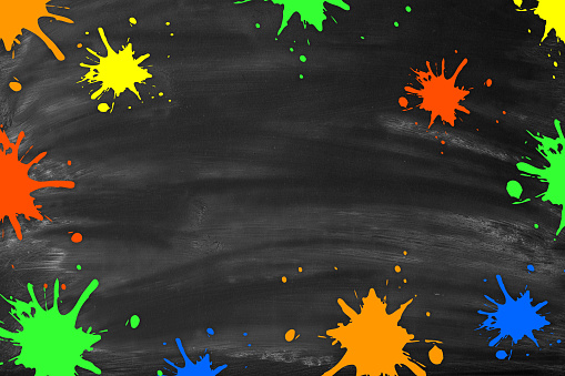 Blank chalkboard with multi colored ink blobs. Blackboard with chalk traces and smudges. Space for copy.
