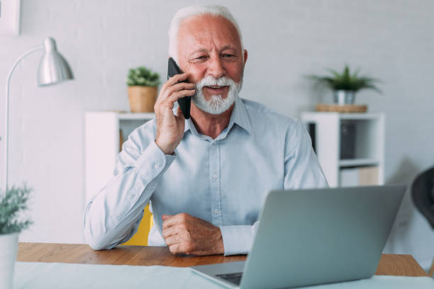 istock Businessman working on laptop and talking on cellphone. 1705503371