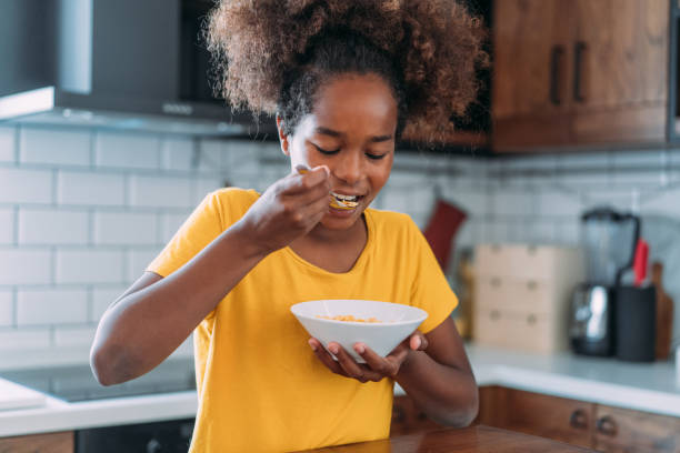 Happy girl having breakfast at home.