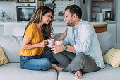 Lovely young couple drinking coffee at home.