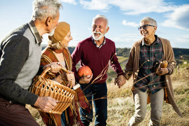 istock Happy mature couples talking while going on a picnic in autumn day. 1705520325