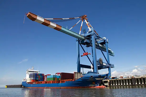 With the help of a hugh crane this container ship is unloaded in Bremerhaven, Germany.