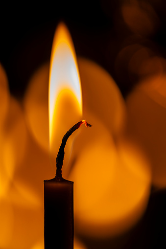 Burning church wax candles in a candlestick, close up. Concept of religion, faith, rituals, monasteries, temples, churches, rituals