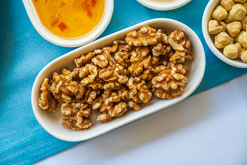 Pile of walnuts in a white porcelain bowl on the breakfast table