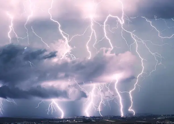 Photo of A plane takes off from Avram Iancu airport in Cluj with thunderbolt effect in the background.