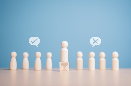 Open-mindedness, public hearing, elections concept. Wooden figures dolls stand above trophy icon wooden cube among others with vote yes or no symbol. Volunteers, candidates, constituency electorates.