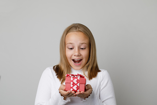 Portrait of happy excited child with surprise gift present on white background