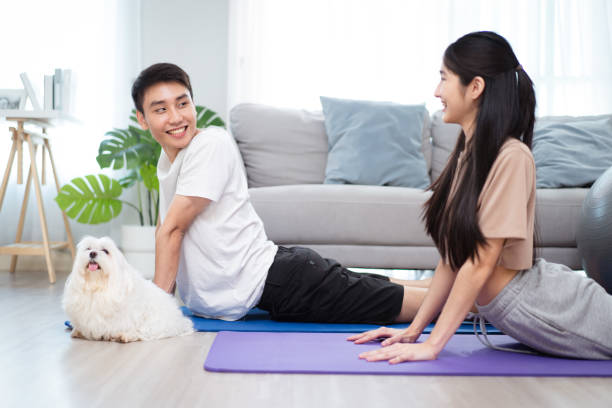 istock Asian lovely couple doing a home exercise with a dog. 1705586823