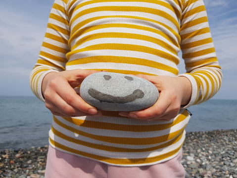Beach Pebble stone in kid's hands