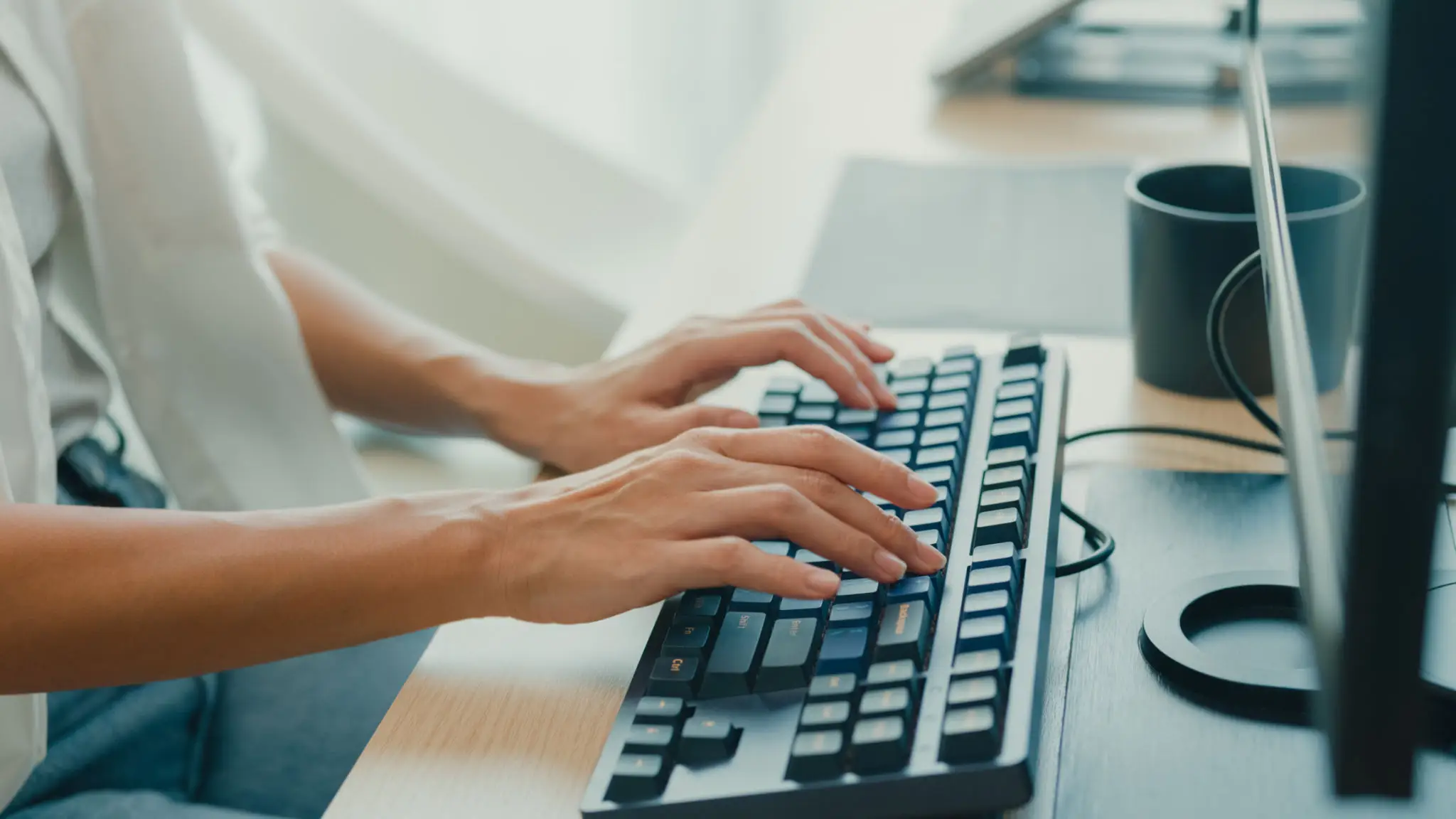 Closeup young Asian woman software developers using computer to write code sitting at desk with multiple screens work at office. Programmer development.