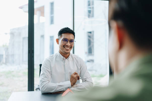 istock Guarantee, mortgage, agreement, contract, signed, real estate agent pointing to documents for customers to read the agreement before signing important documents 1705618552