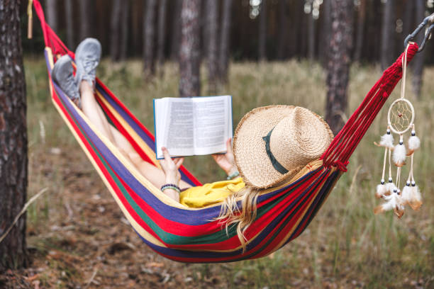 istock Woman resting in hammock and reading book 1705621851
