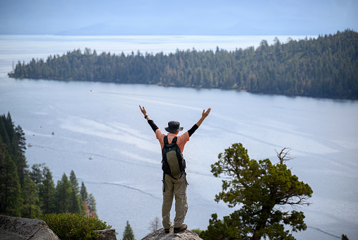 Tourist raising arms at Emerald Bay. Lake Tahoe. California.