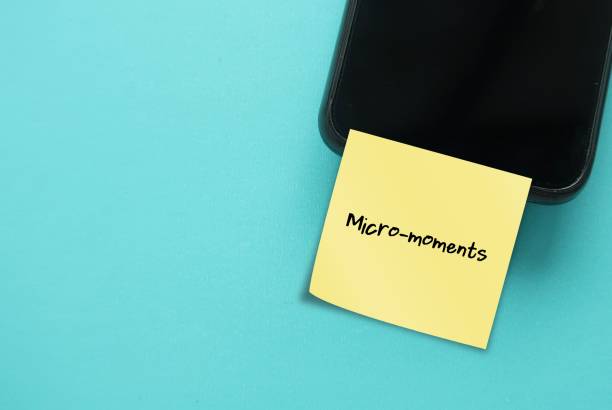 istock Mobile smart phone on blue copy space background with buzzword note MICRO- MOMENTS, small moments of consumers before making a purchase decision - short precious times when brands get to interact with consumer 1705632455