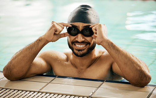 Happy, man and portrait of athlete in swimming pool with gear for training, workout or exercise for wellness, goals or fitness. Swimmer, goggles or smile for sport, challenge or success in water polo