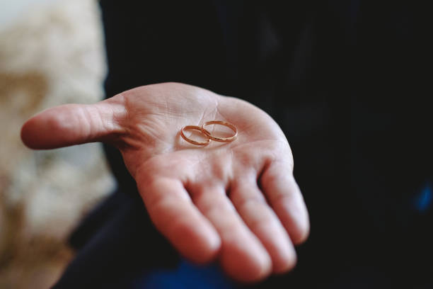 istock Single gold and silver wedding rings on hands. 1705657479