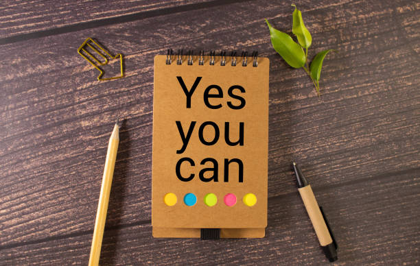 istock a wooden table and a notebook that says Yes you can 1705691447